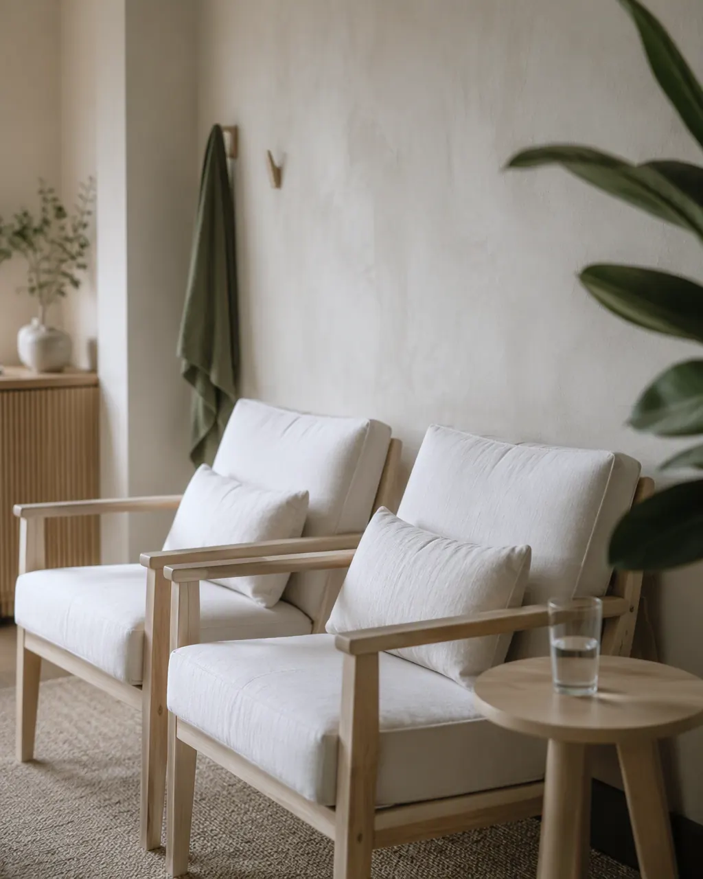 Waiting area with two armchairs, a side table and a plant
